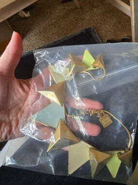 Adia Kibur statement necklace features a gold-toned chain with geometric pyramid